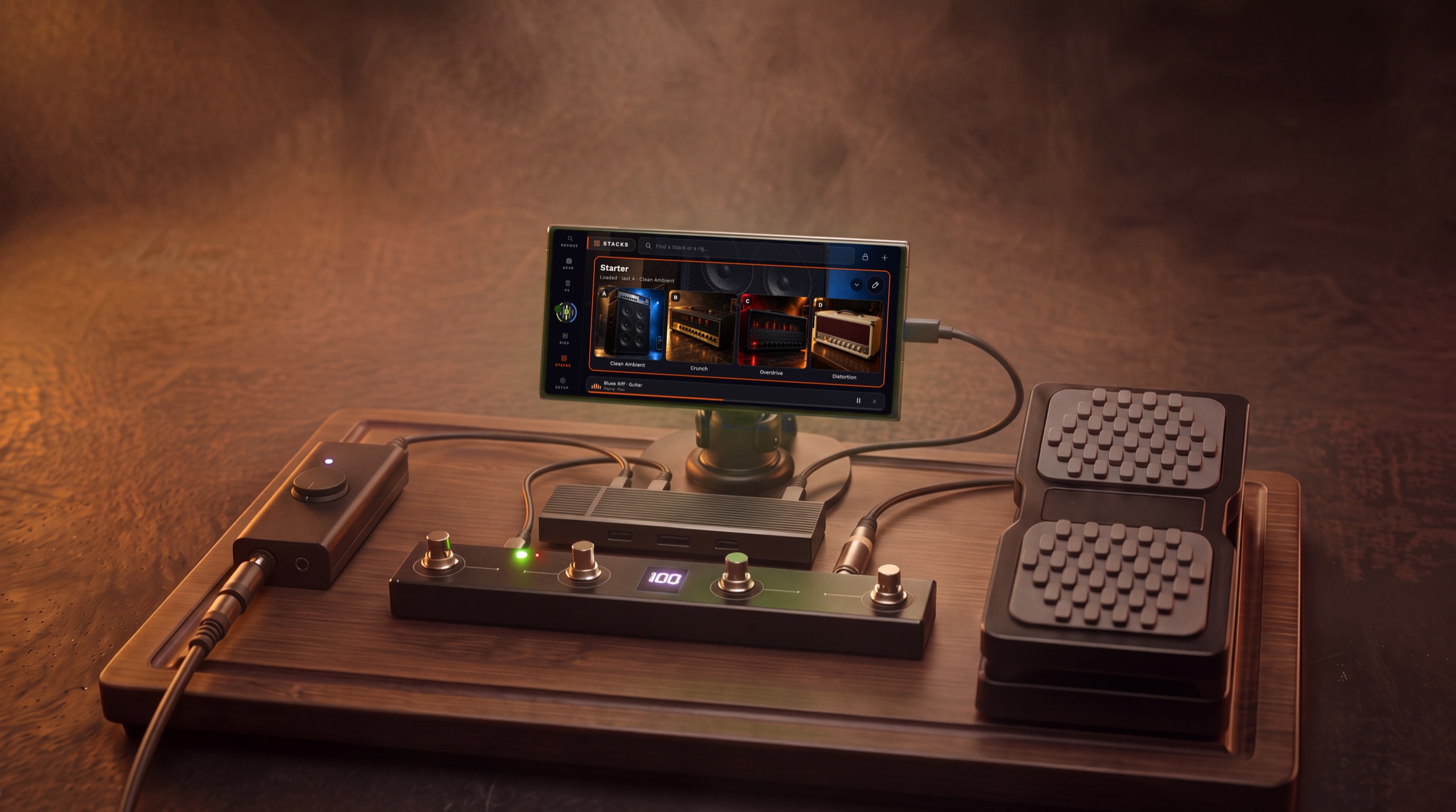 A phone on a mount above a pedalboard, running AmpHoarder on its side with a Stack of four rigs; a foot controller, a guitar interface, a USB-C hub and an expression pedal around it