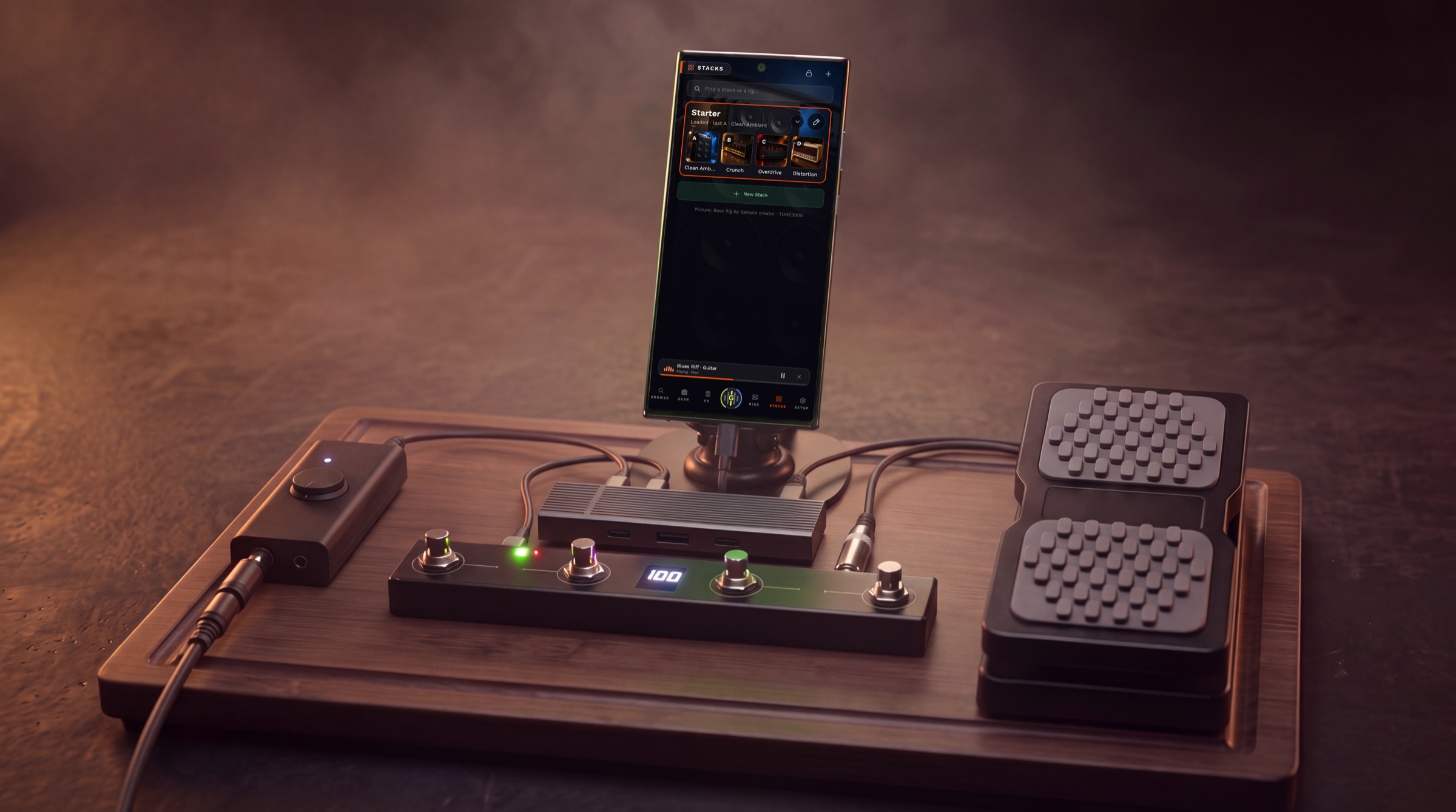 The full setup on a board: guitar cable into the interface, interface and foot controller into a USB-C hub, the hub into the phone, the expression pedal into the controller